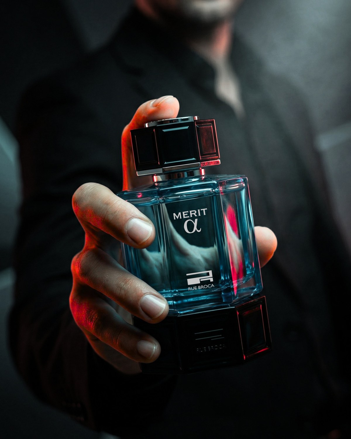 A hand holding Merit Alpha perfume against dark clothing with teal and red highlights — AI perfume imagery by The Media Lab.