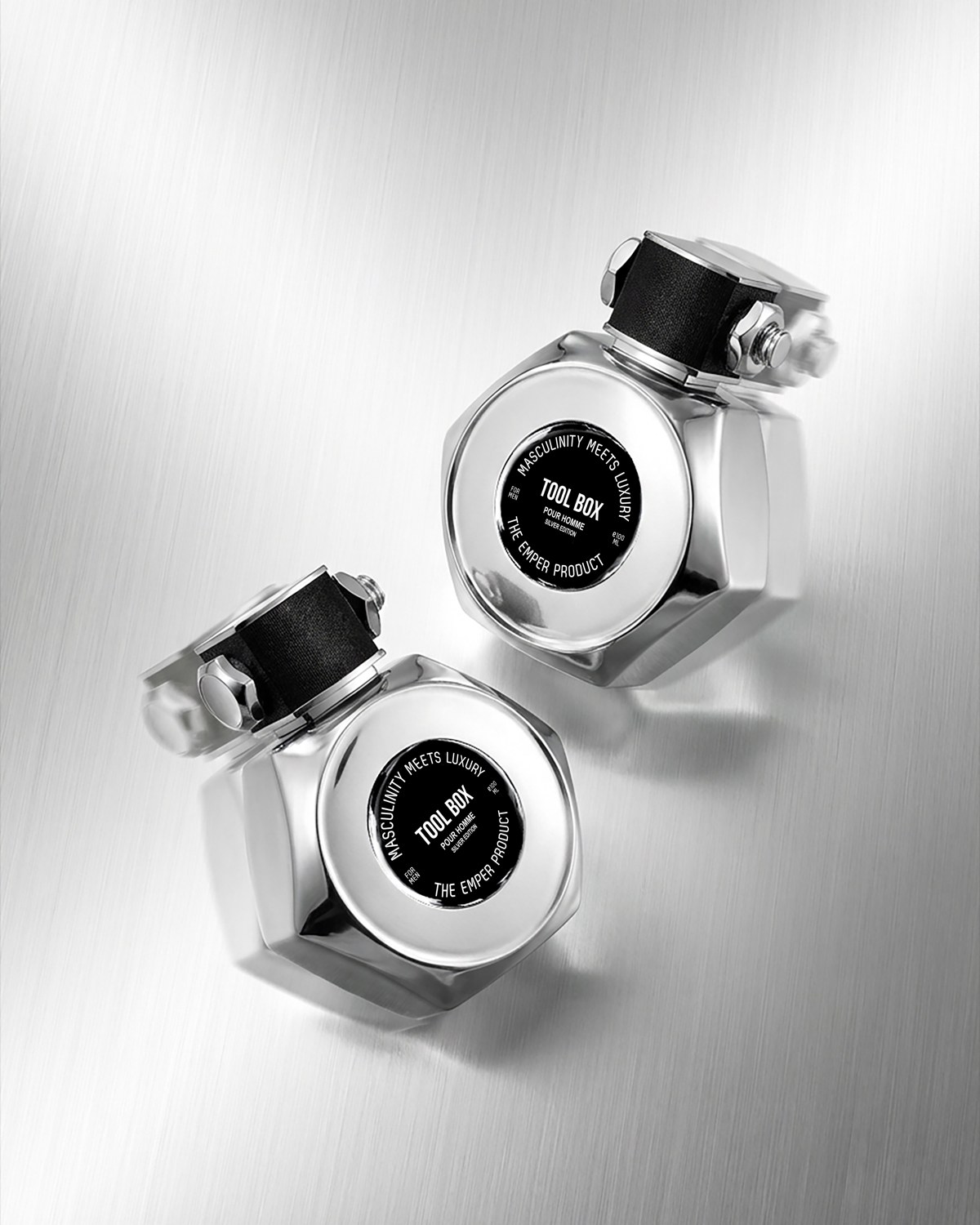 Three silver Emper Tool Box perfume bottles arranged diagonally against a pale background — AI perfume imagery by The Media Lab.