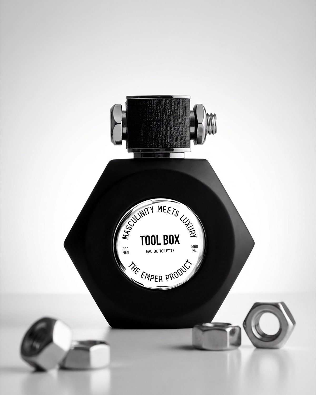 Black Emper Tool Box perfume bottle with metal nuts against a white backdrop — AI perfume imagery by The Media Lab.